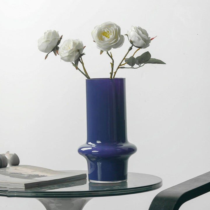 Cosik Home deep blue glass vase with a flared base, holding white roses on a table.