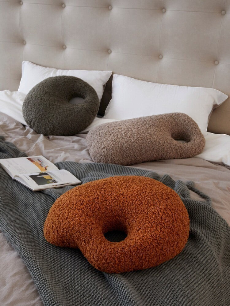 Cosik Home abstract bouclé donut throw pillow in burnt orange, featuring a textured, curly fabric and an organic, asymmetrical O-shape.