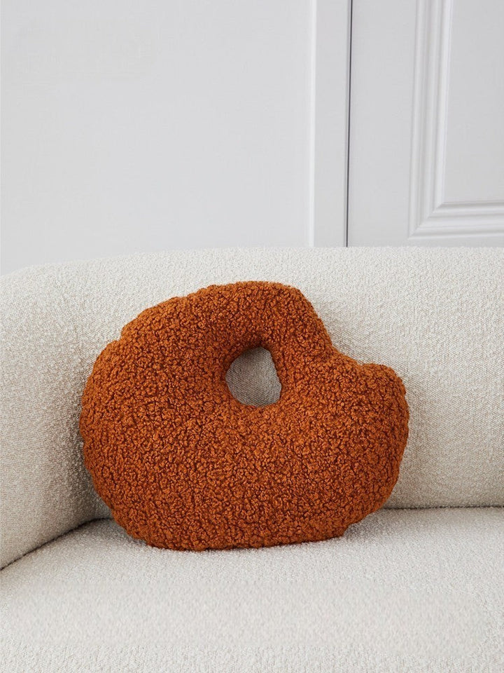 Cosik Home abstract bouclé donut throw pillow in burnt orange with an off-center cutout.
