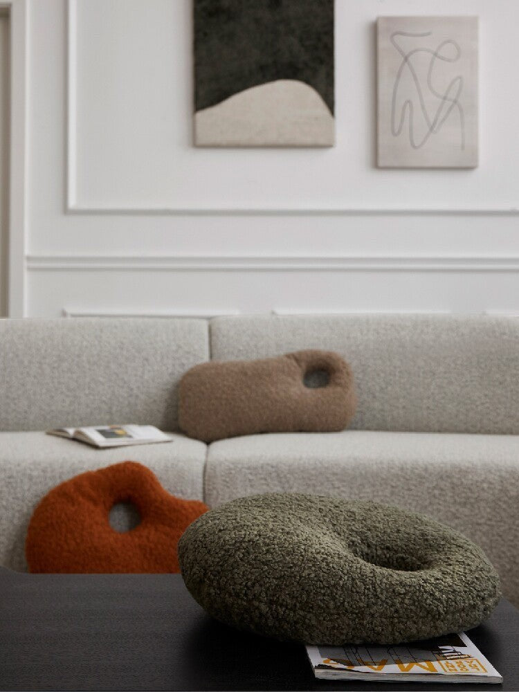 Cosik Home abstract bouclé donut throw pillow in olive green, featuring a textured, curly fabric and an organic, asymmetrical shape with a cutout.