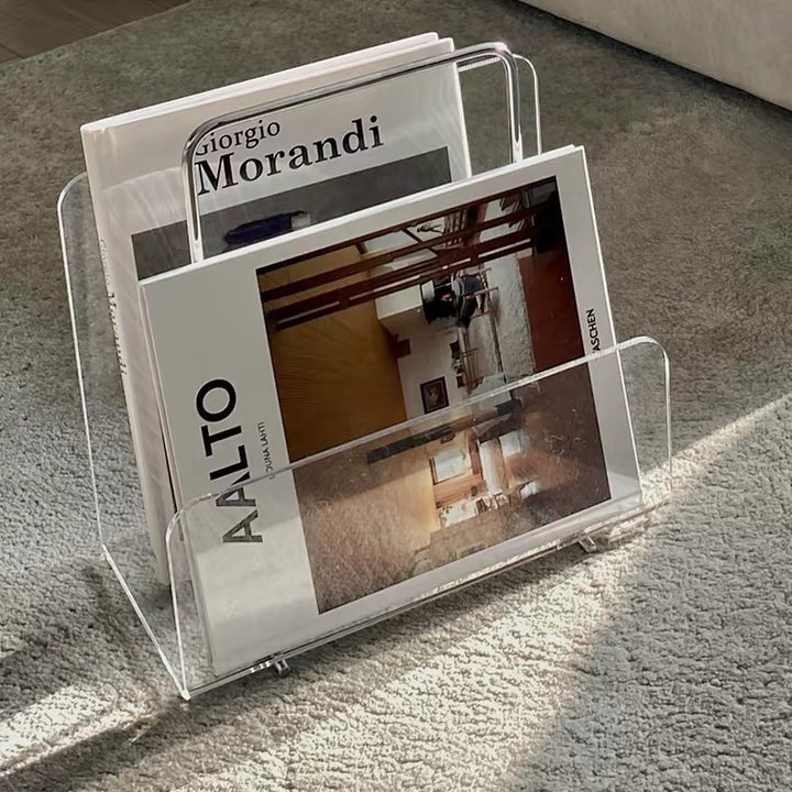 Cosik Home clear acrylic magazine book rack holding two art books on a grey carpet.
