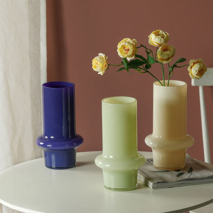 Cosik Home set of 3 glass vases in purple, light green, and cream. Cylindrical shape with a flared base.