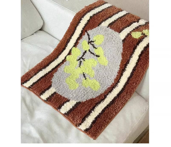 Cosik Home retro tufted plush bath mat with brown, cream, and grey stripes and a light green floral design.