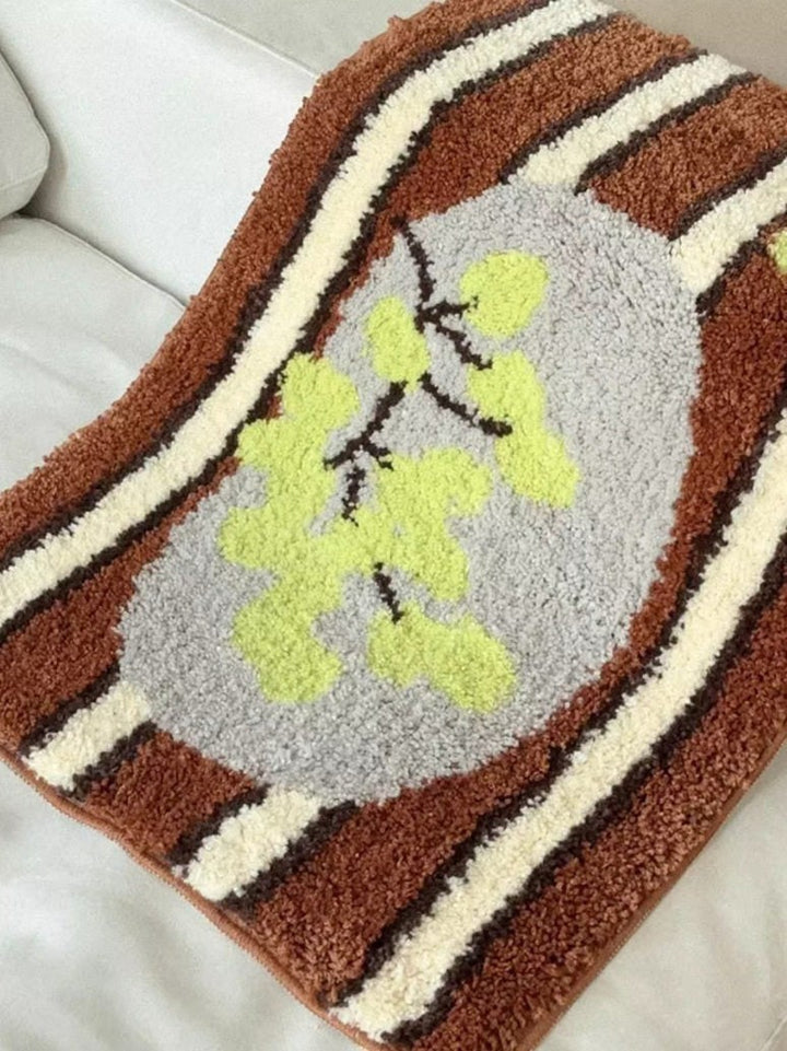 Cosik Home retro tufted plush bath mat with brown, cream, and dark brown stripes and a grey oval with lime green leaves.